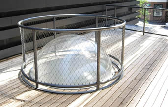 Uma rede protetora redonda em torno de uma lâmpada de vidro bola-dada forma para protegê-la dos danos.